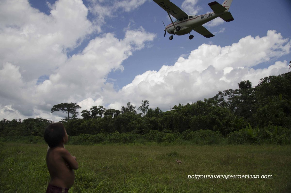 A Huaorani child watches as Alas de Socorro takes off, Huaorani Lodge