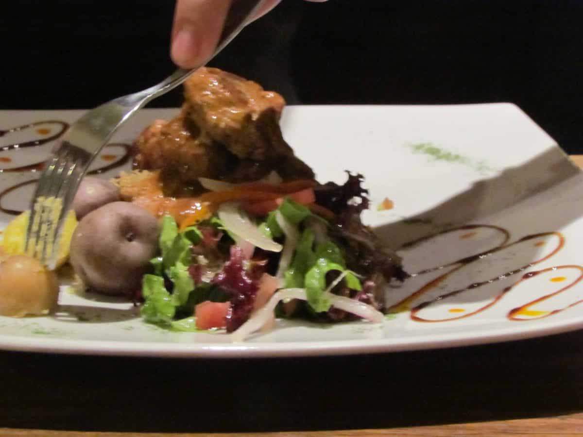 Alpaca with salad and potatoes; Deva, Cusco, Peru | ©Angela Drake