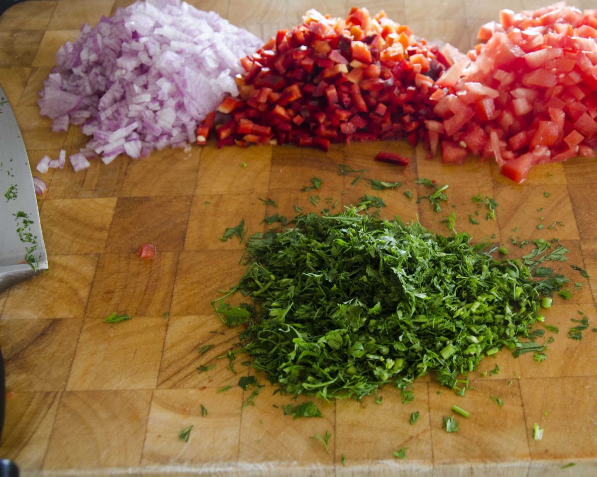 Cebollas cortadas en cubitos, pimientos, tomates y cilantro para nuestro ceviche vegetariano