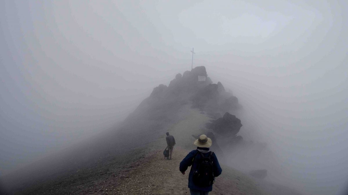Two hikers take advantage of the clearing fog to head to the peak