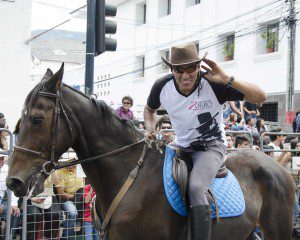 A man leans forward cupping his ear to better hear a greeting from the crowd