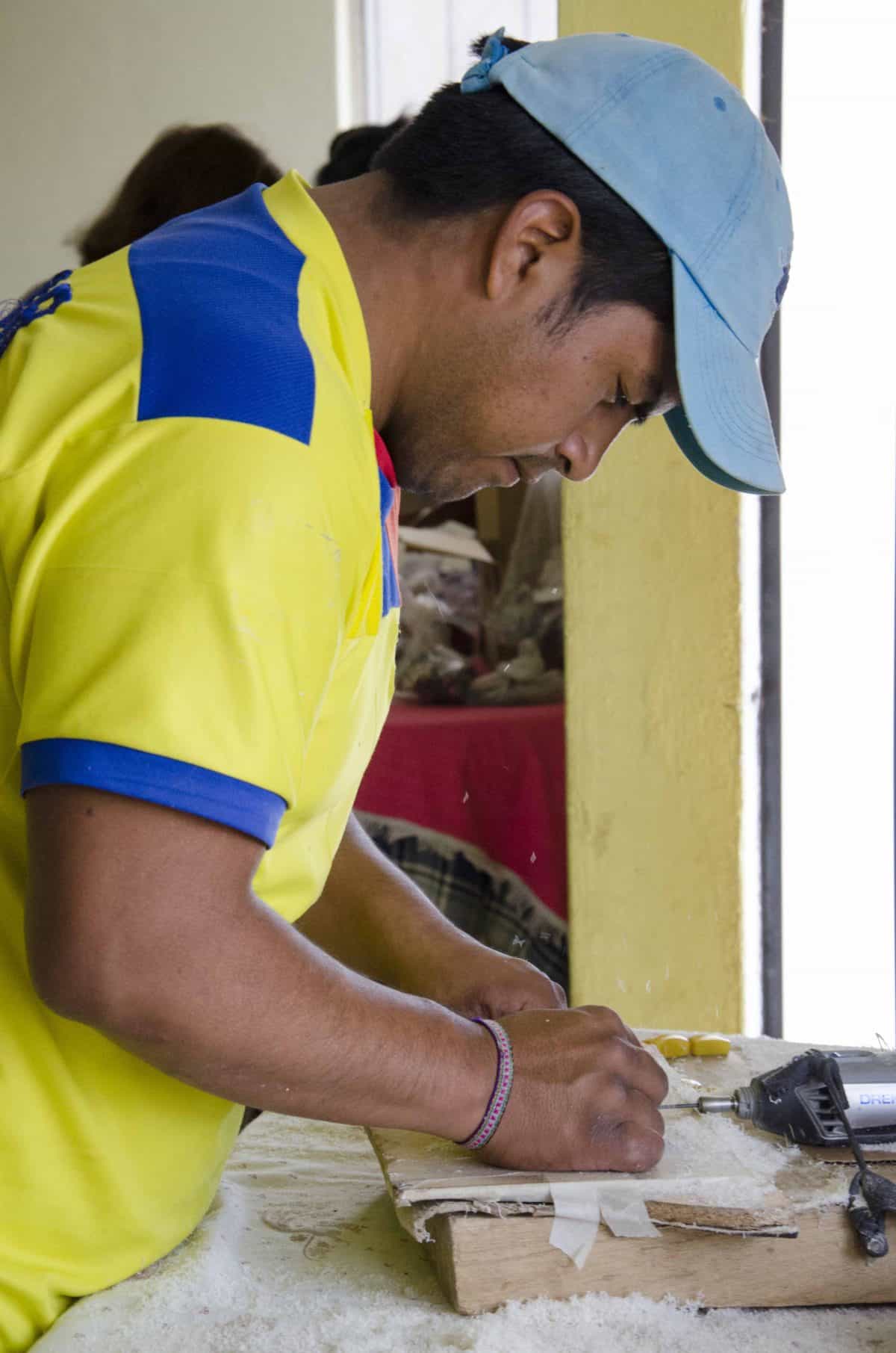 Jose Moquinche drilling holes into tagua beads, Calderon, Ecuador