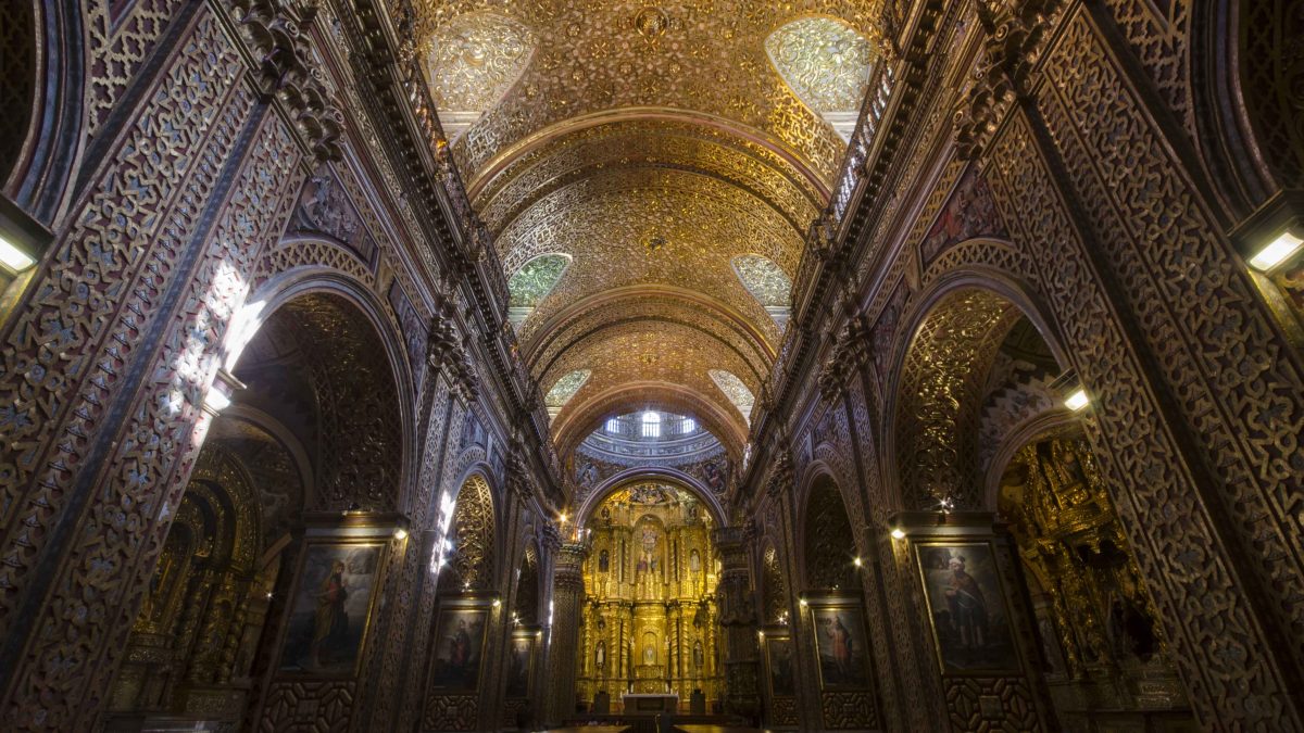 View of the gold leaf ceiling, the main altar, and darker side apses