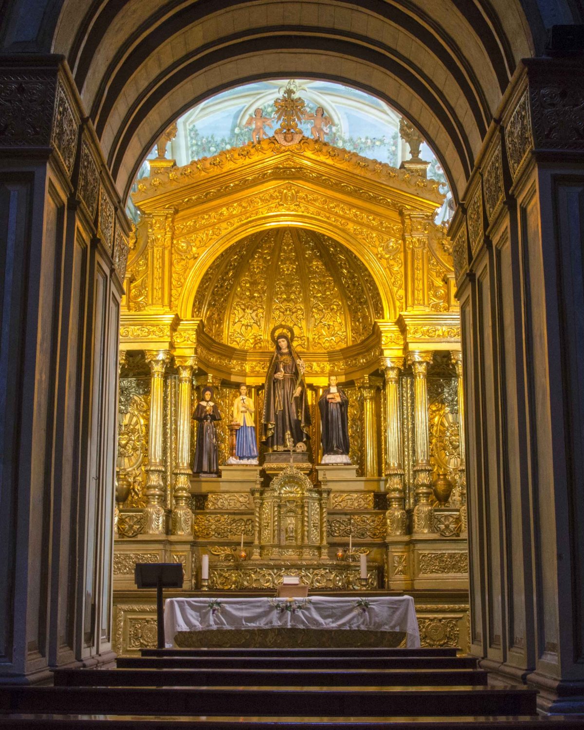 Capilla lateral bañada en oro con estatua central de la Virgen María