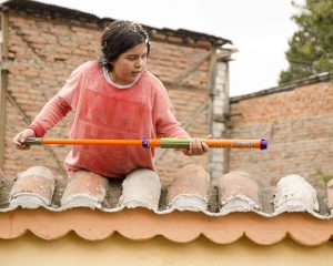 Adolescent boy preparing to shoot a water gun at passing parade