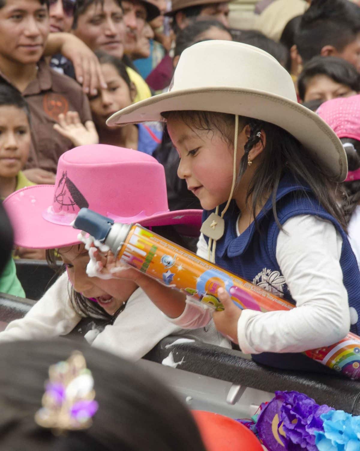 Little girl with can of party foam, Carnaval in Guaranda, Ecuador