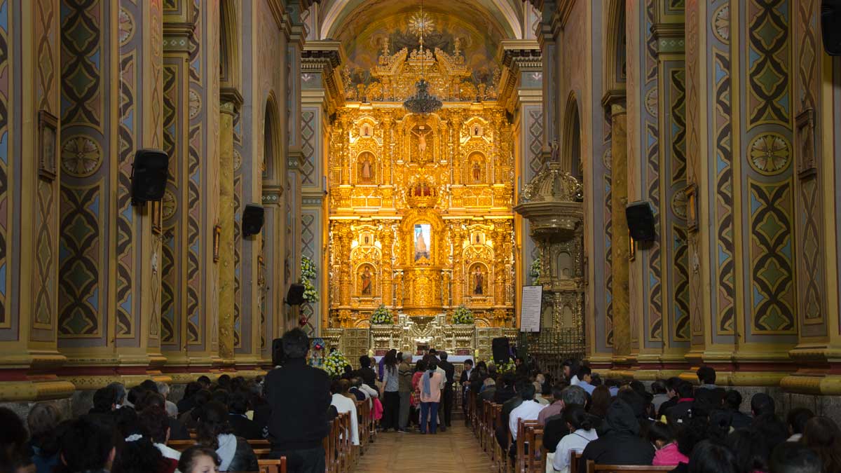 The main altar glows from afar in El Quinche, Ecuador | ©Angela Drake