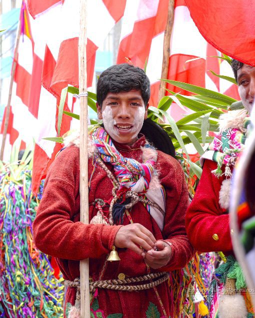 A young man dressed in red with a flag of red and white rays