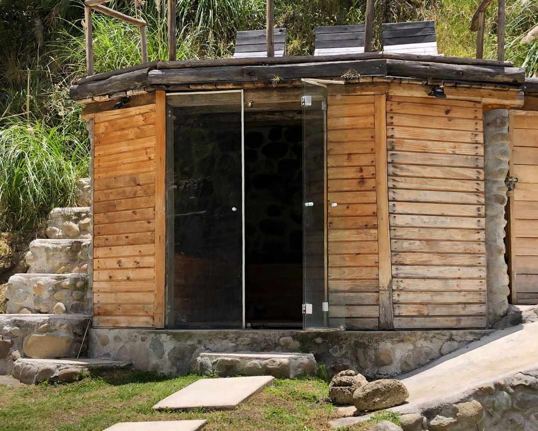 Edificio de madera rústica con puertas de cristal que conducen a una sauna
