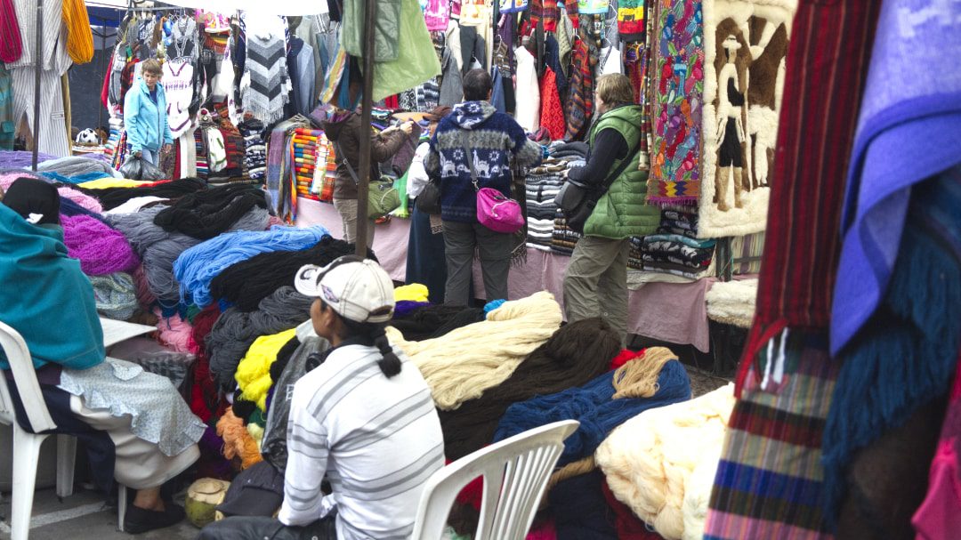 Tightly packed market stalls full of yarn and woven goods