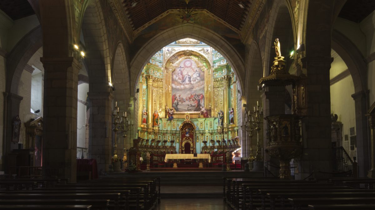 The main altar of Quito's City Cathedral stands in stark light that highlights the gold leaf and painting showing the ressurection of Christ