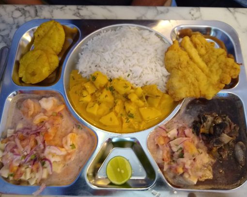 Una Bandeja de La Yapa incluye cuatro platos diferentes de marisco, arroz y patacón