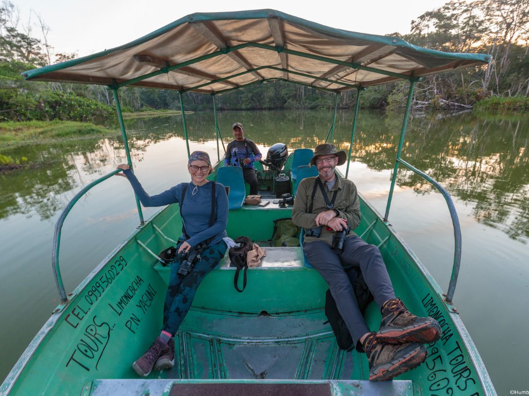 Three birders seated in a motorboat floating on Laguna Limoncocha 