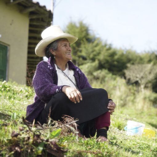 Woman seated on a hillside in Cuemal, Peru.