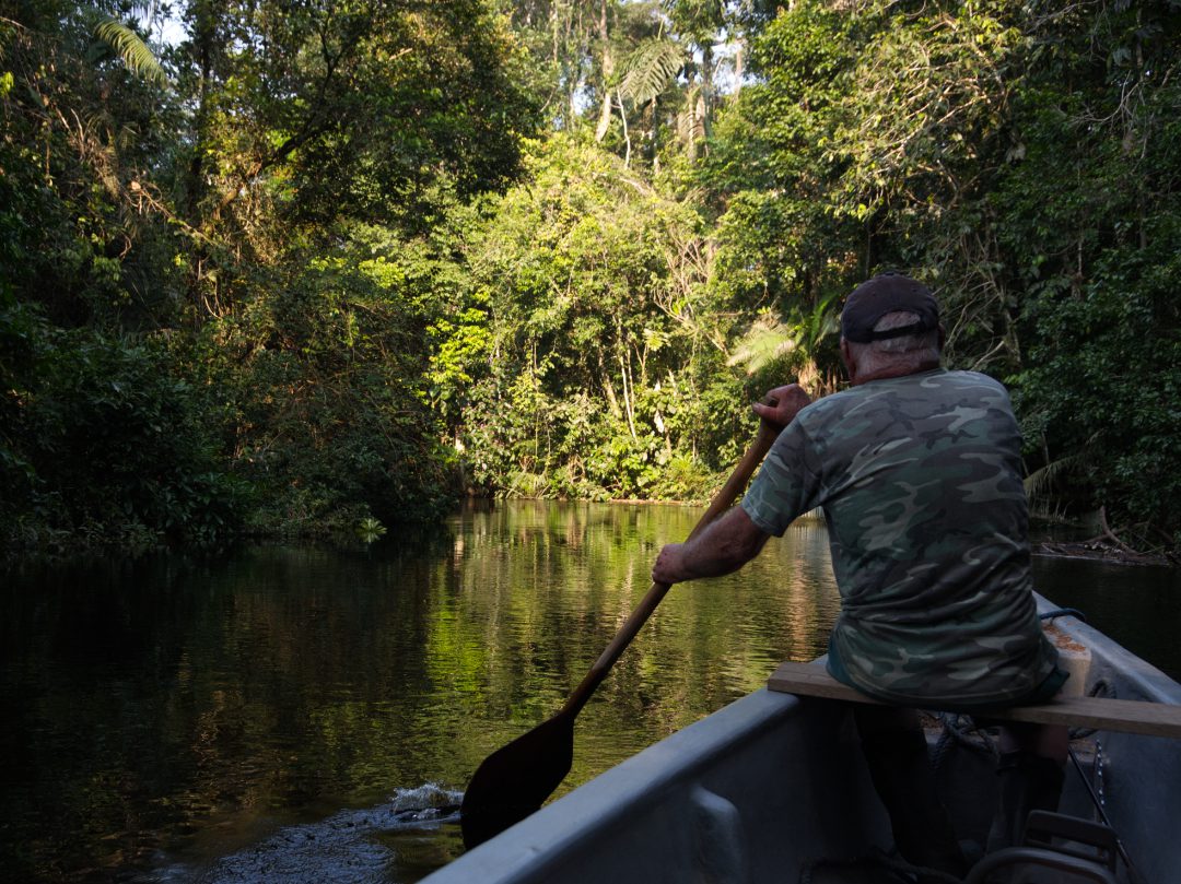 Randy at the head of a fiberglass canoe, working a traditional wooden paddle  | ©Angela Drake