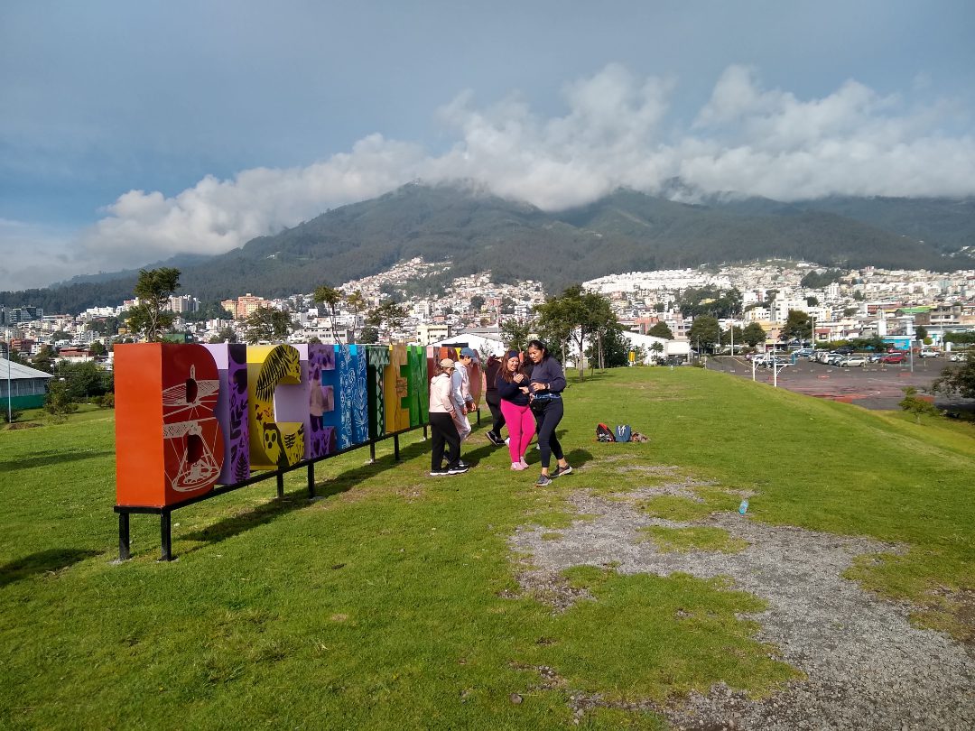 Un grupo de mujeres se reúne frente a las coloridas letras que forman el nombre del Parque Bicentenario.