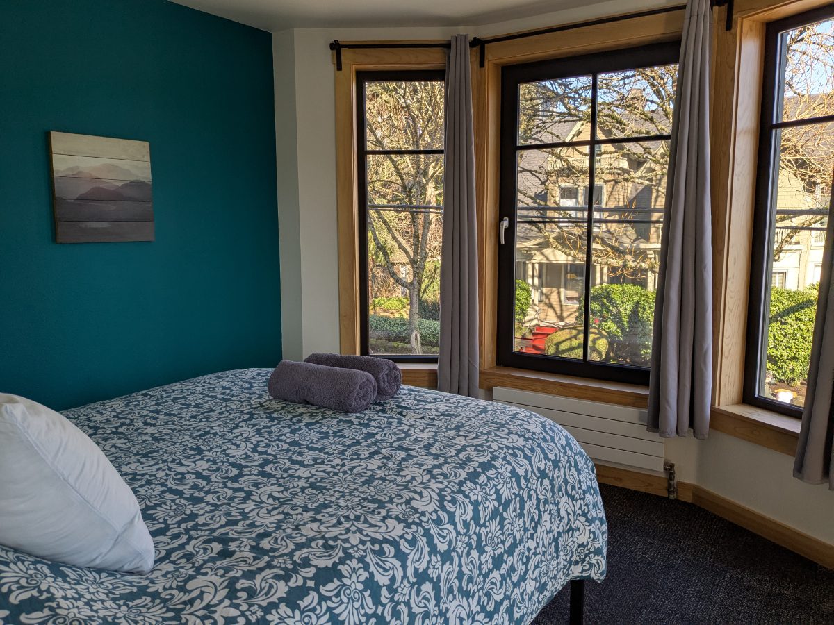 My favorite room at the hostel includes a private bath Queen bed looks out through a triple set of windows