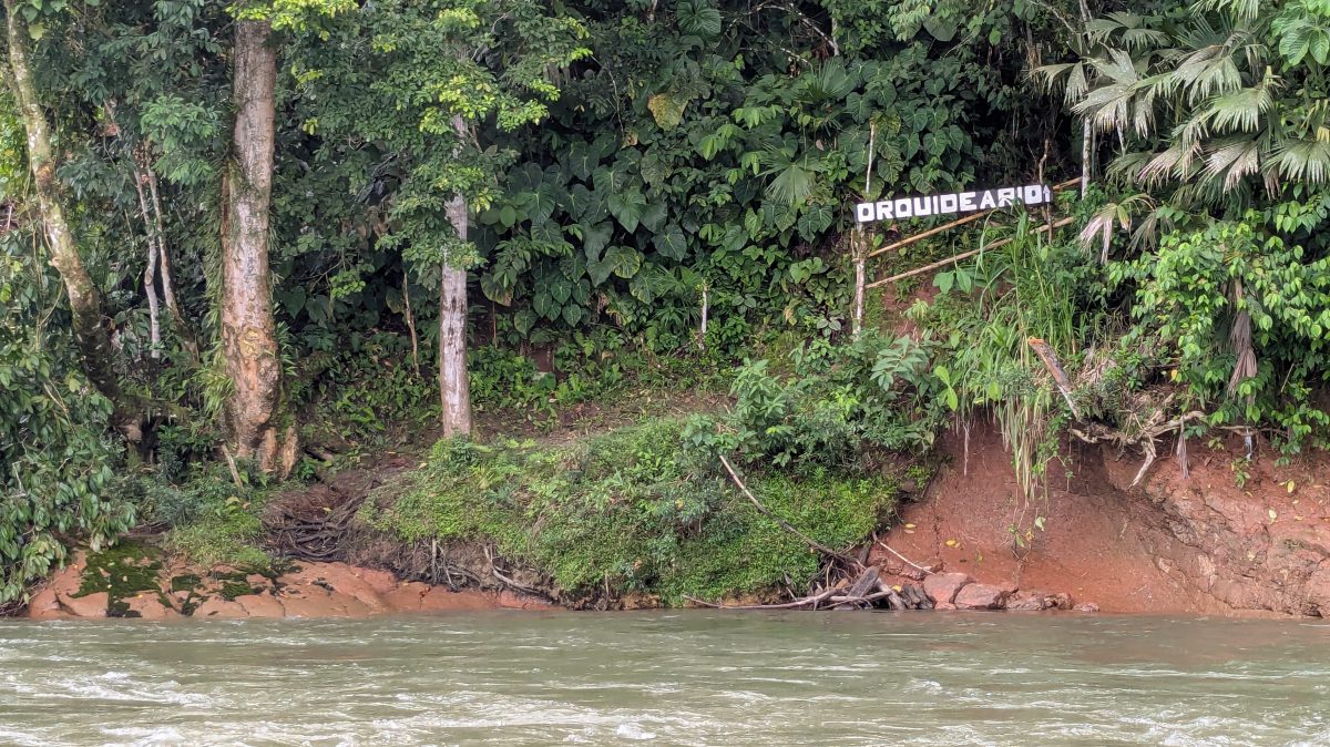 A sign reading ORCHIDEARIO invites visitors along the banks of the Napo River A sign reading ORCHIDEARIO invites visitors along the banks of the Napo River, Puerto Misahualli, Ecuador