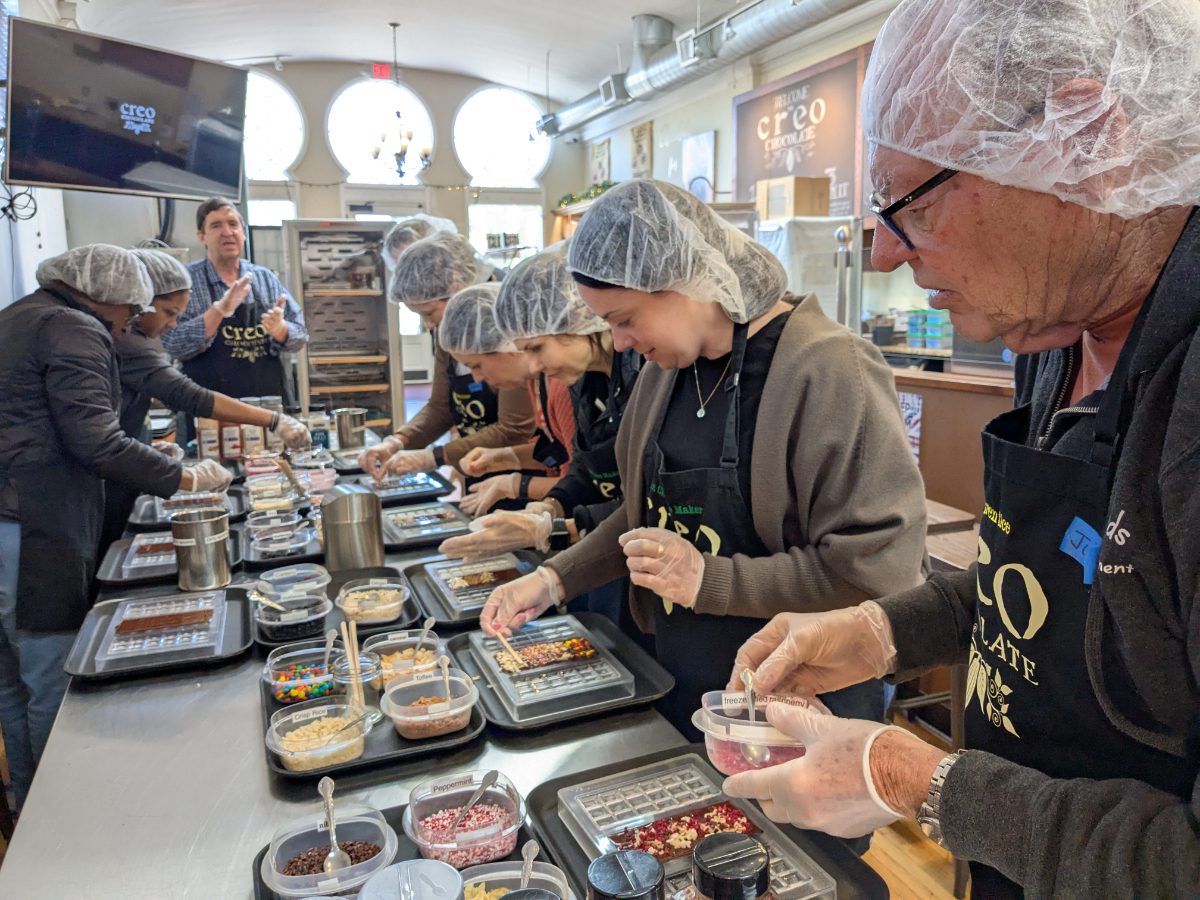 Making Chocolate Bars A class of chocolate apprentices hard at work adding ingredients to liquid chocolate.
