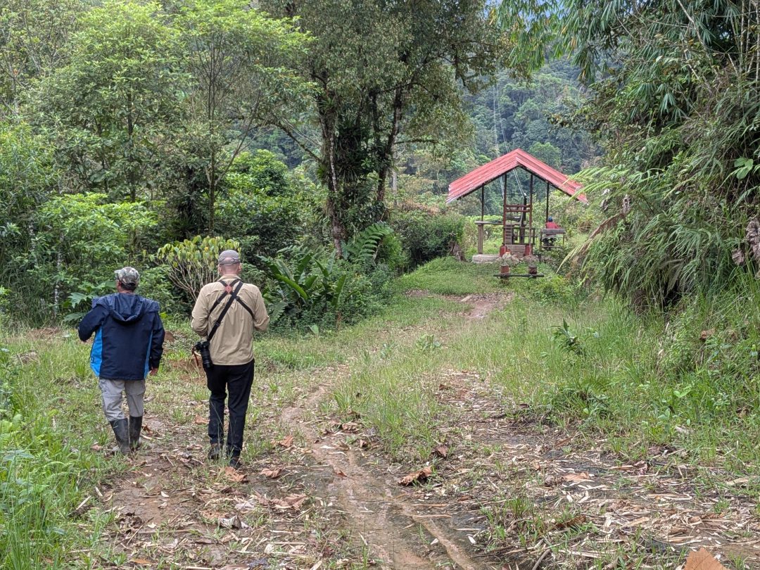 Jose and Scott walk towards the cable car crossing the river valley.