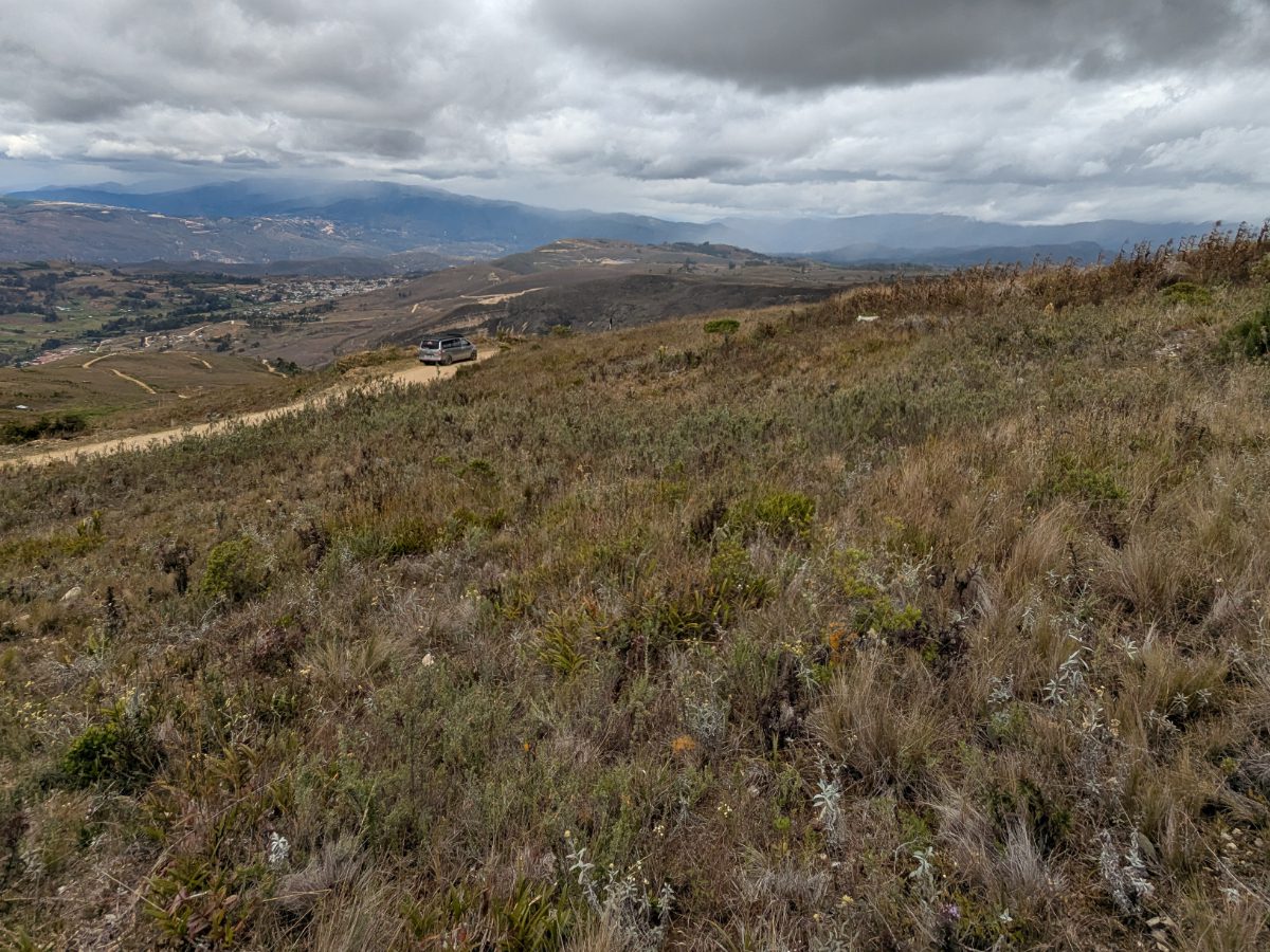 On the road from Cuemal, Peru View from a mountainside above the road to Cuemal, Peru, with a car parked on the narrow roadside and the valley stretching out below.
