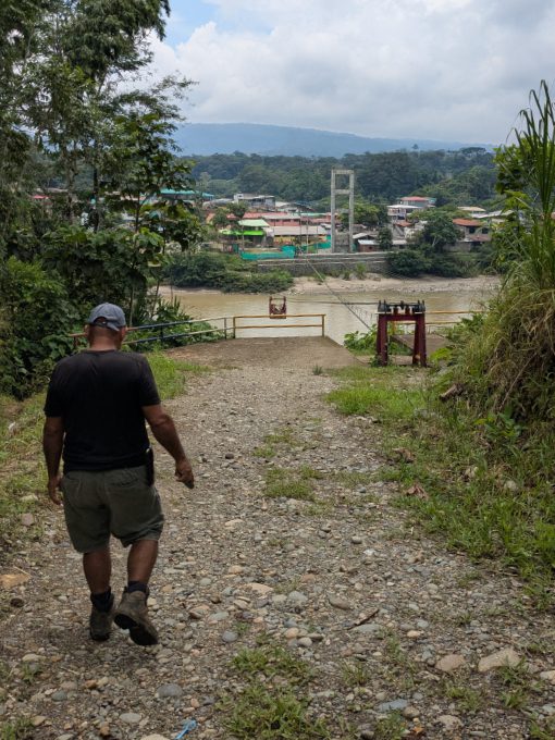 A man walks down a gravel path towards the aerial tram that crosses the Napo River at Puerto Misahualli.