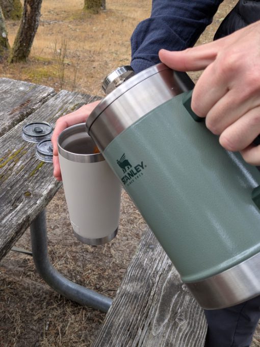Pouring coffee from a Stanley French Press into a Yeti Travel Mug while at camp.