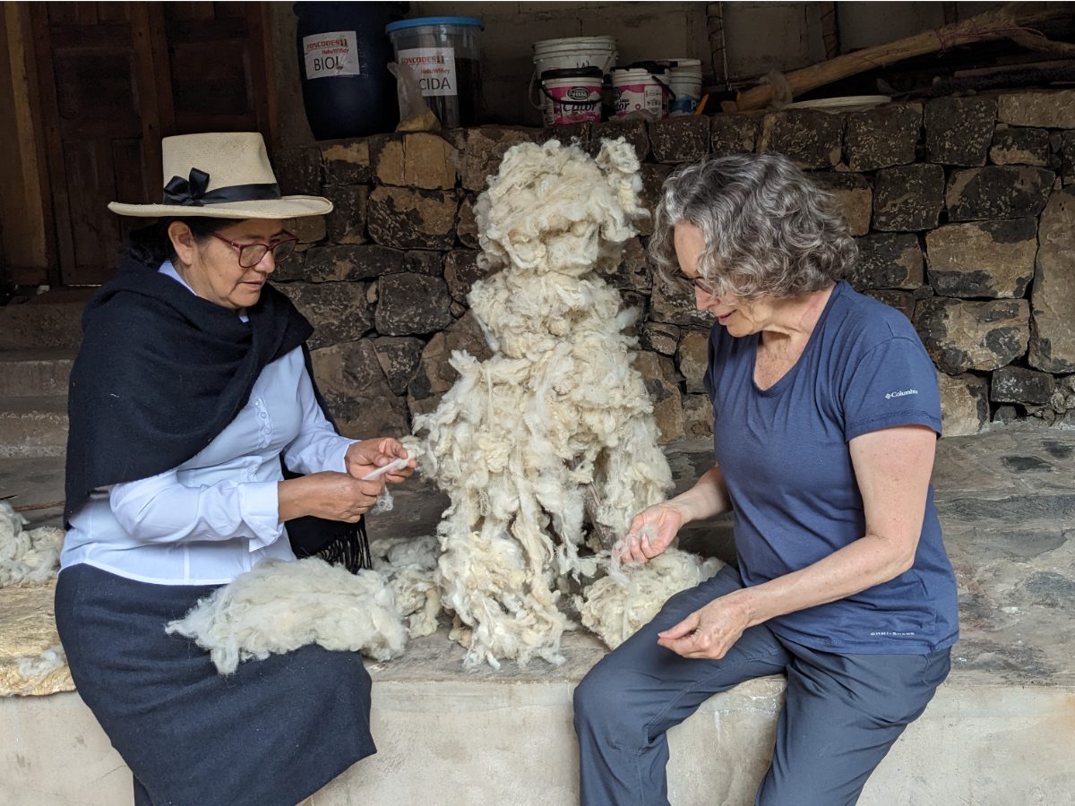 Doña Isabela teaches Angie how to clean wool.