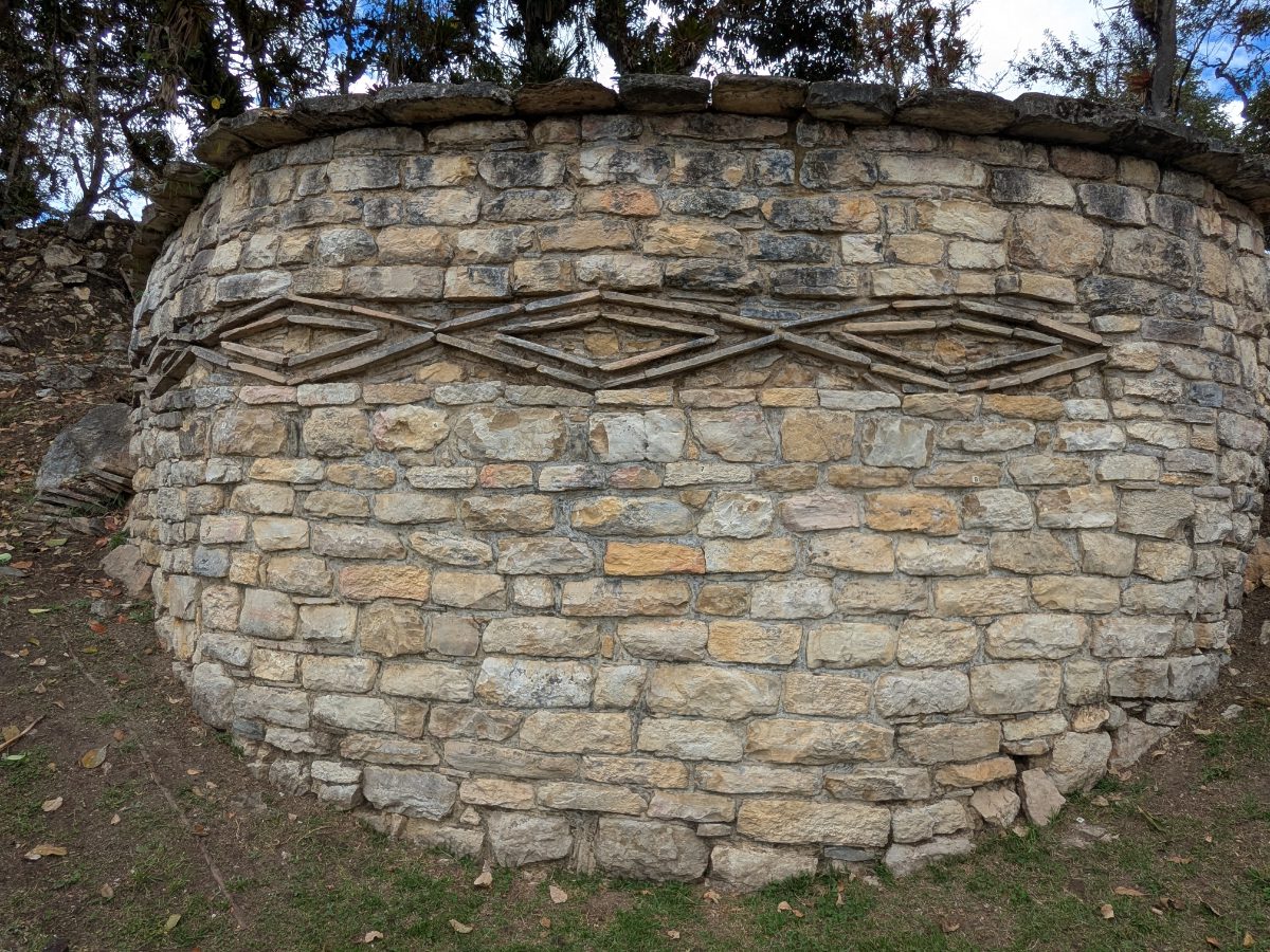 An ancient, circular building at Kuelap is decorated with diamond-shaped rocks 