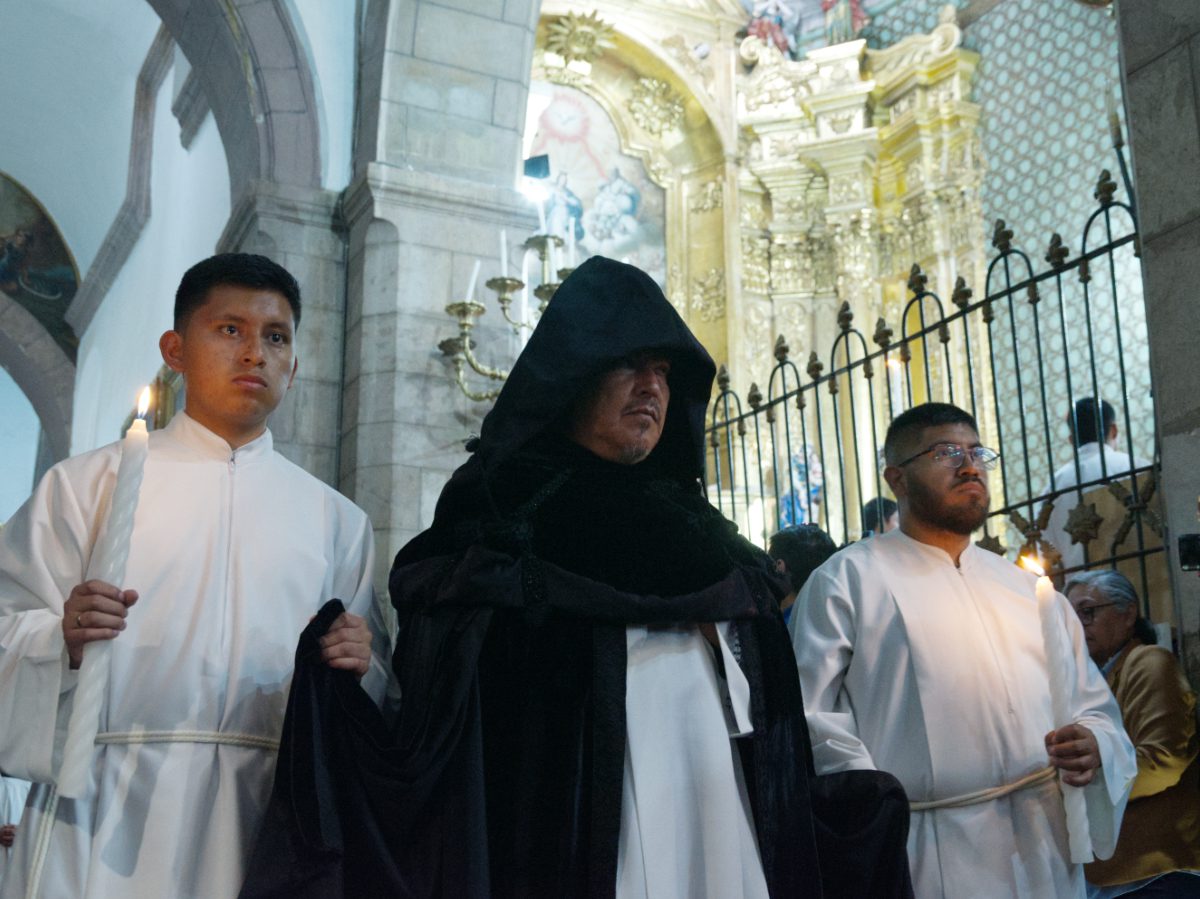 Hooded canon with trailing robe accompanied by white-robed acolytes, Holy Week procession Quito Cathedral