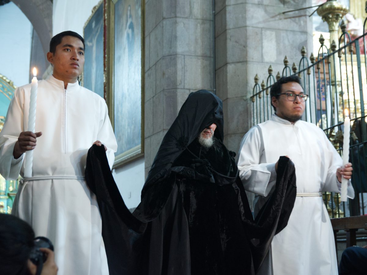 Final canon in black robes with trailing garment guided by acolytes, Arrastre de Caudas at Quito Cathedral