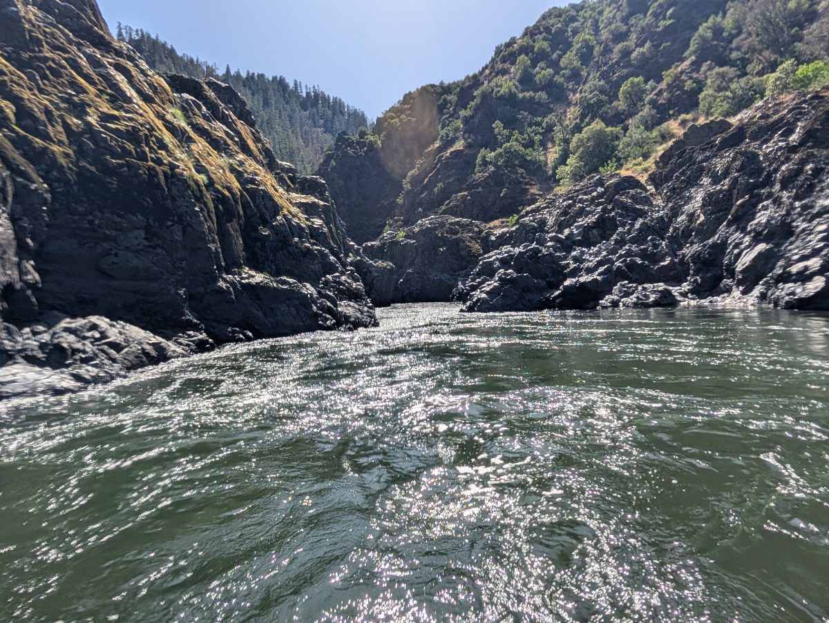 Entering the start of several challenging rapids along the Rogue River at Mule Creek Canyon where the river shores turn from sand to solid rock and rise above the fast flowing river.