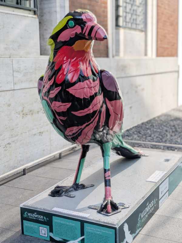 From the front, the Bloom crow sculpture is a bold statement, from its turquoise eye to the coxcomb like red flower painted at its throat.