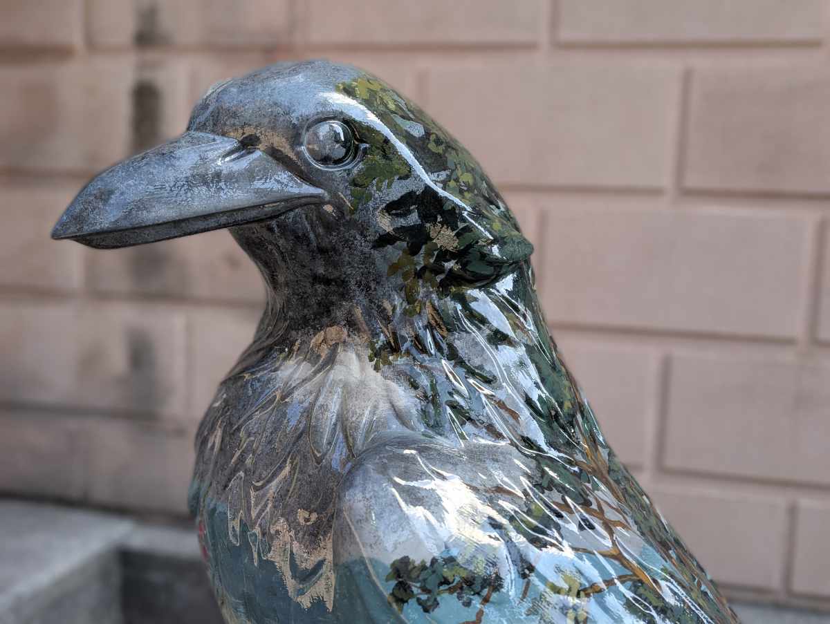 A close-up of head and shoulders of the crow statue Oregon Botanica.